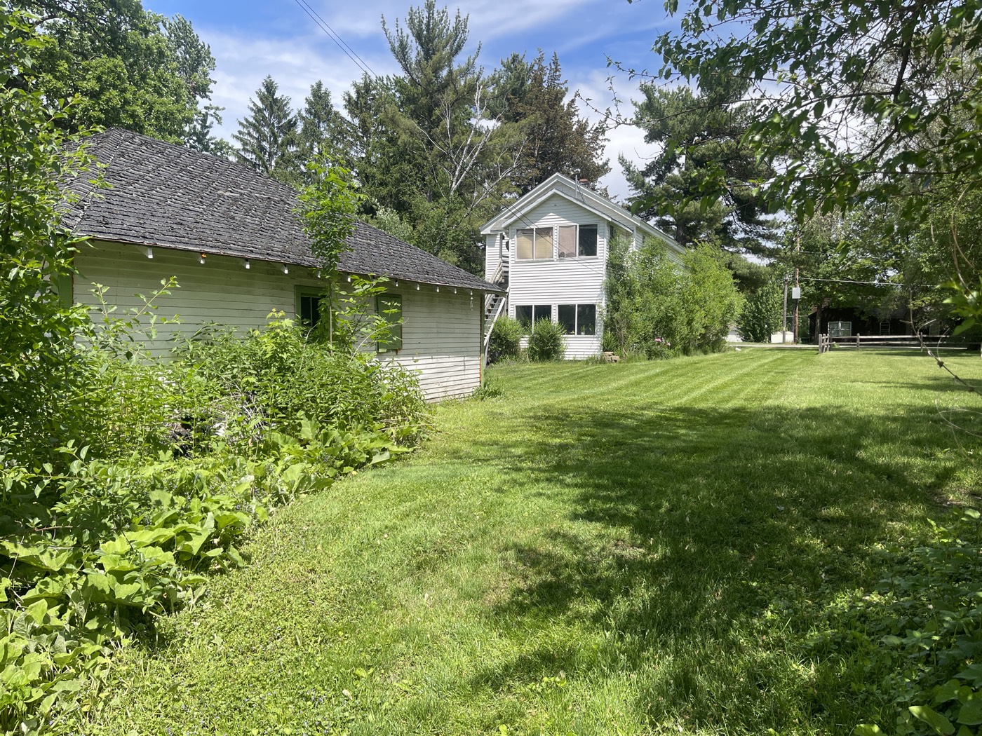 Freshly mowed lawn beside a white farmhouse